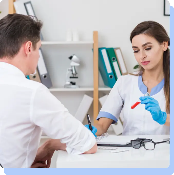 A female clinician in a white lab coat and blue gloves showing a medical sample vial to a patient during a consultation in a bright office.
