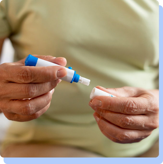 A close-up of a person's hands holding a semaglutide injection pen and carefully removing the cap.