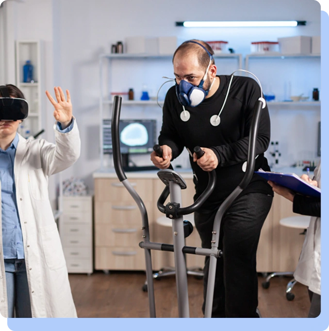 A medical research facility where a man wearing a metabolic testing mask and heart-rate sensors is exercising on an elliptical trainer. To his left, a researcher in a white lab coat wears a VR headset and raises a hand, while another person on the right holds a clipboard to record data.