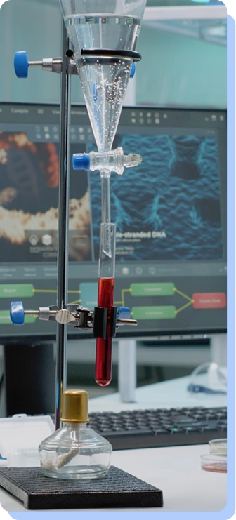 A tall, glass laboratory apparatus (separatory funnel) containing a red liquid, mounted on a stand above a workspace with a computer monitor displaying molecular data in the background.