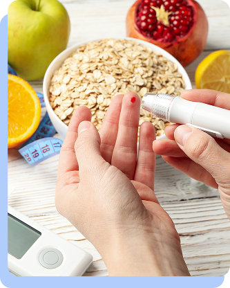 Close-up of a person using a lancet device to prick their finger for a blood glucose test next to a bowl of oatmeal and fruit.