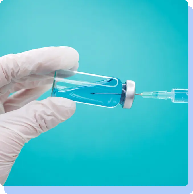 Close-up of a gloved hand holding a vial and syringe with blue background, representing semaglutide injection treatment