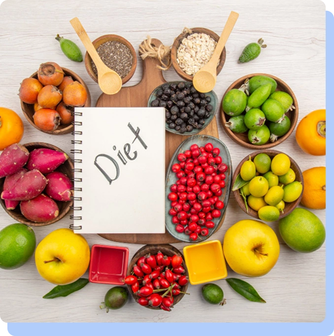 Flat lay view of a wooden table surrounded by small bowls of various fruits, berries, and grains, with a spiral notebook in the center that has the word "Diet" written on it.