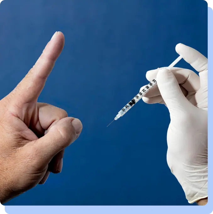 A person’s hand making a "no" gesture toward a syringe held by a gloved hand, illustrating the choice between oral and injectable delivery.