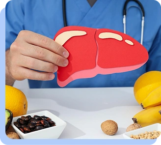 A close-up of a person in medical scrubs holding a small, red paper cutout of a human liver near a bowl of healthy food.