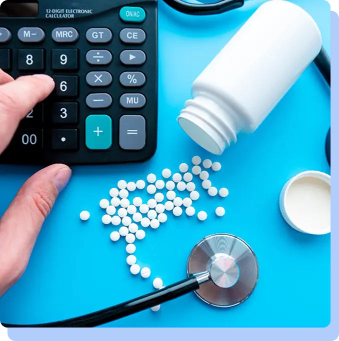 A top-down view of a blue surface featuring a calculator, a stethoscope, a white pill bottle, and a large cluster of small white pills.