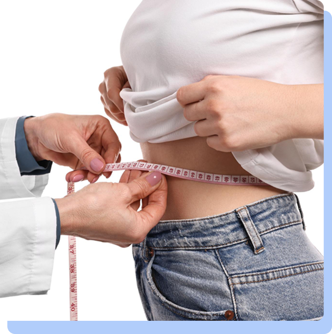 A close-up of a healthcare provider's hands using a pink measuring tape to measure the waist of a patient wearing blue jeans and a white t-shirt.