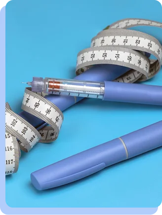 A close-up of a blue semaglutide injection pen resting on a light blue surface, surrounded by a coiled white measuring tape.