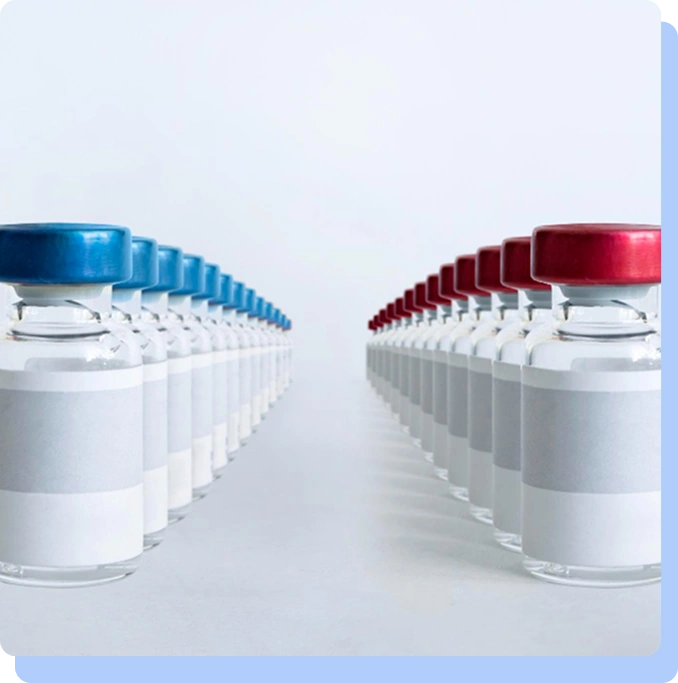 Two long, symmetrical rows of medical vials receding into the distance; the row on the left has blue caps and the row on the right has red caps.