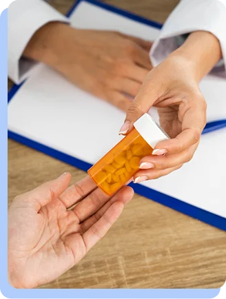 Close-up of hands pouring small pills from an orange prescription bottle into a palm.